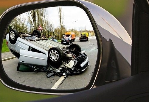 looking through a rear view mirror view at a car that has been in an accident